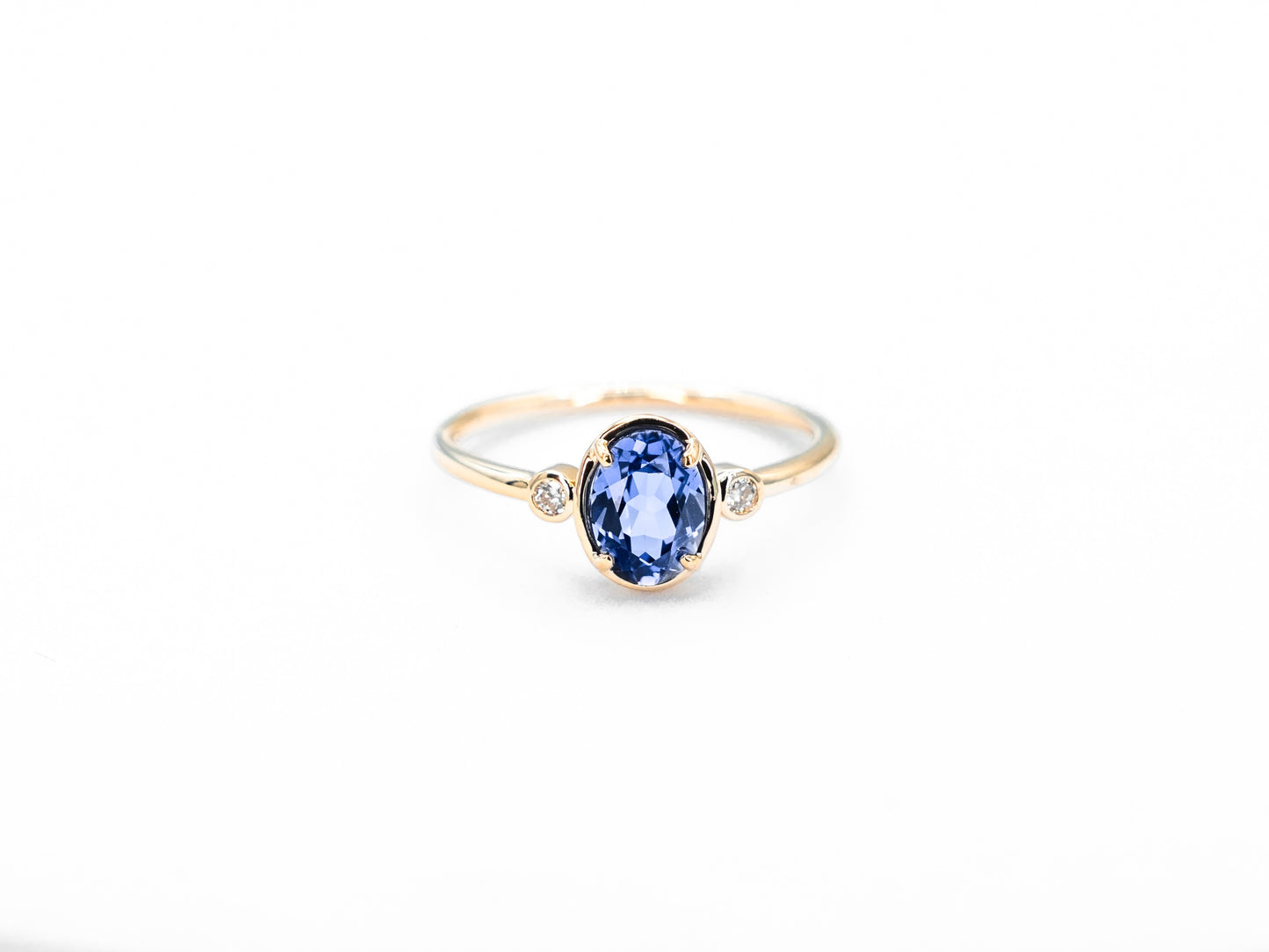 Bezel set oval sapphire diamond ring yellow gold front view