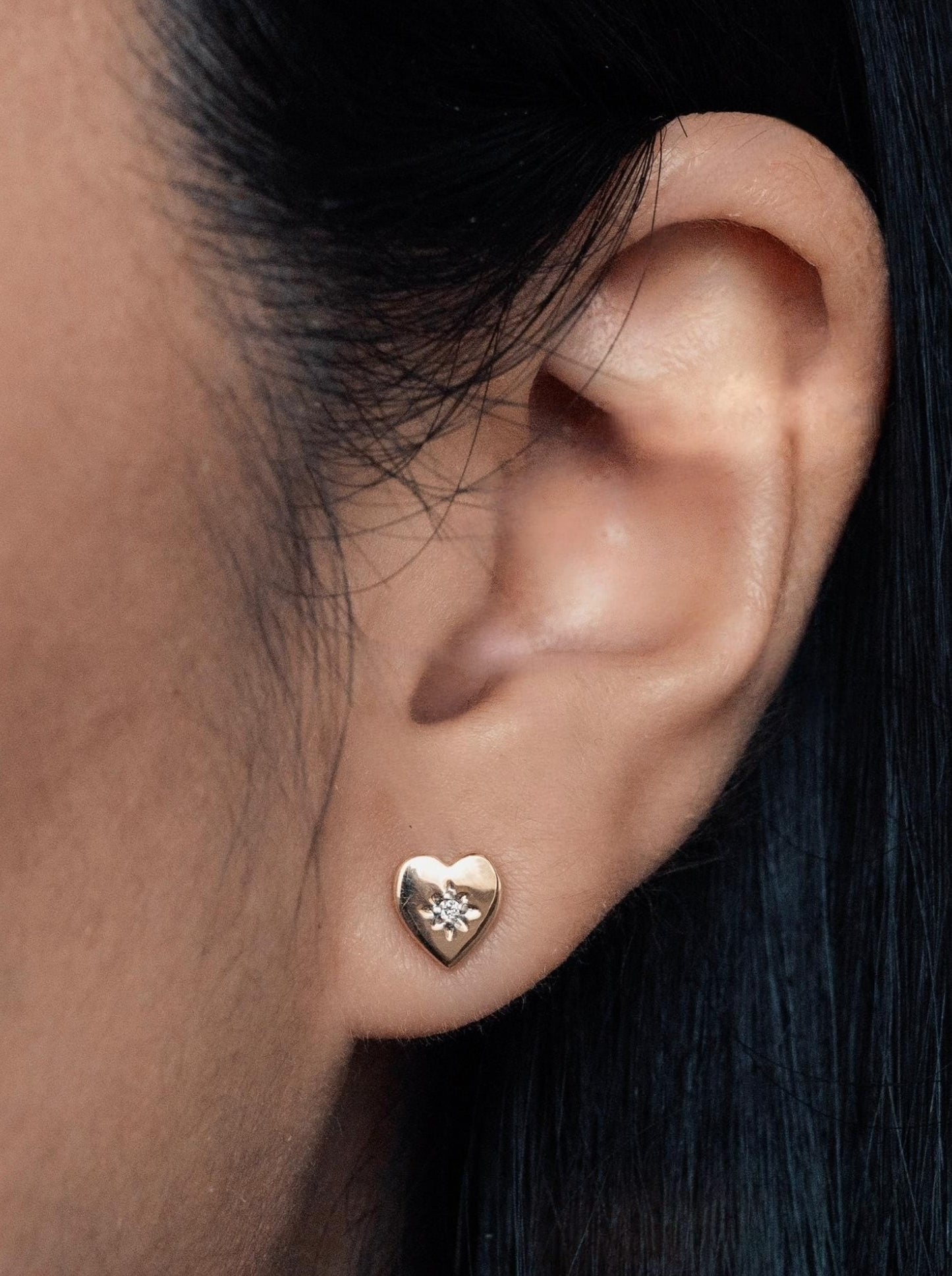 14k yellow gold, lab diamond, Northstar heart stud earrings worn on ear, front and side view