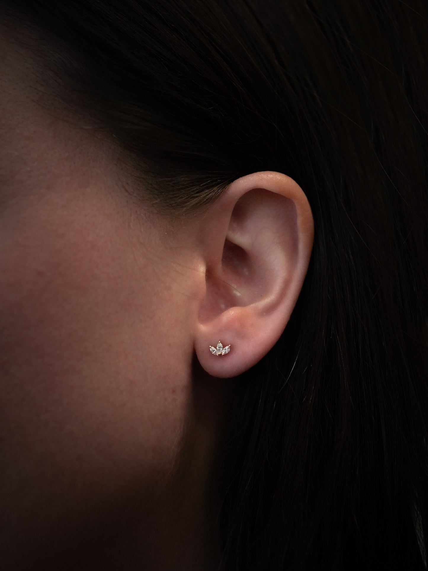 yellow gold marquise diamond stud earrings being worn on ear, side view