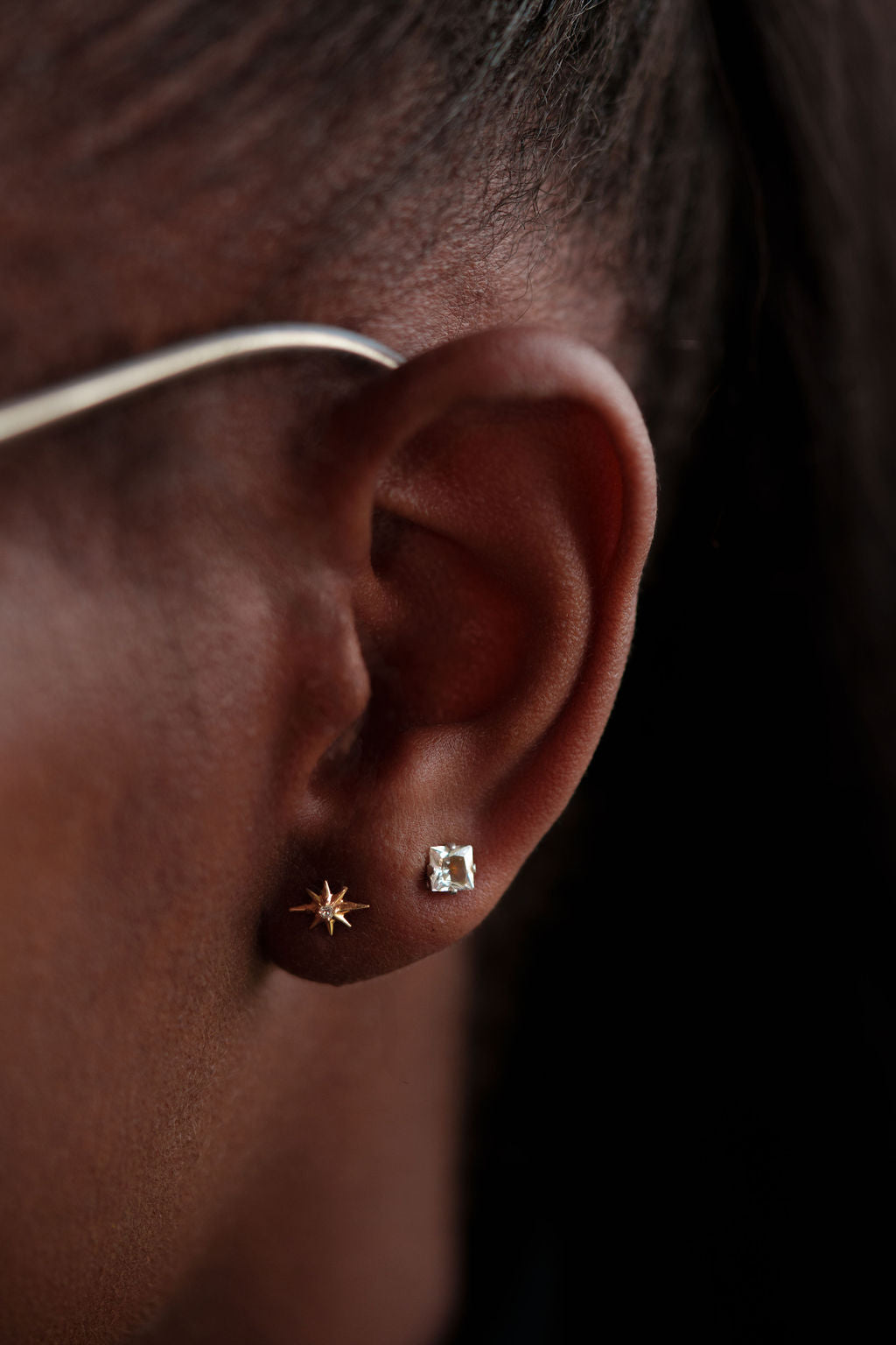 14k yellow gold, lab diamond North Star stud earrings being worn on ear, side view