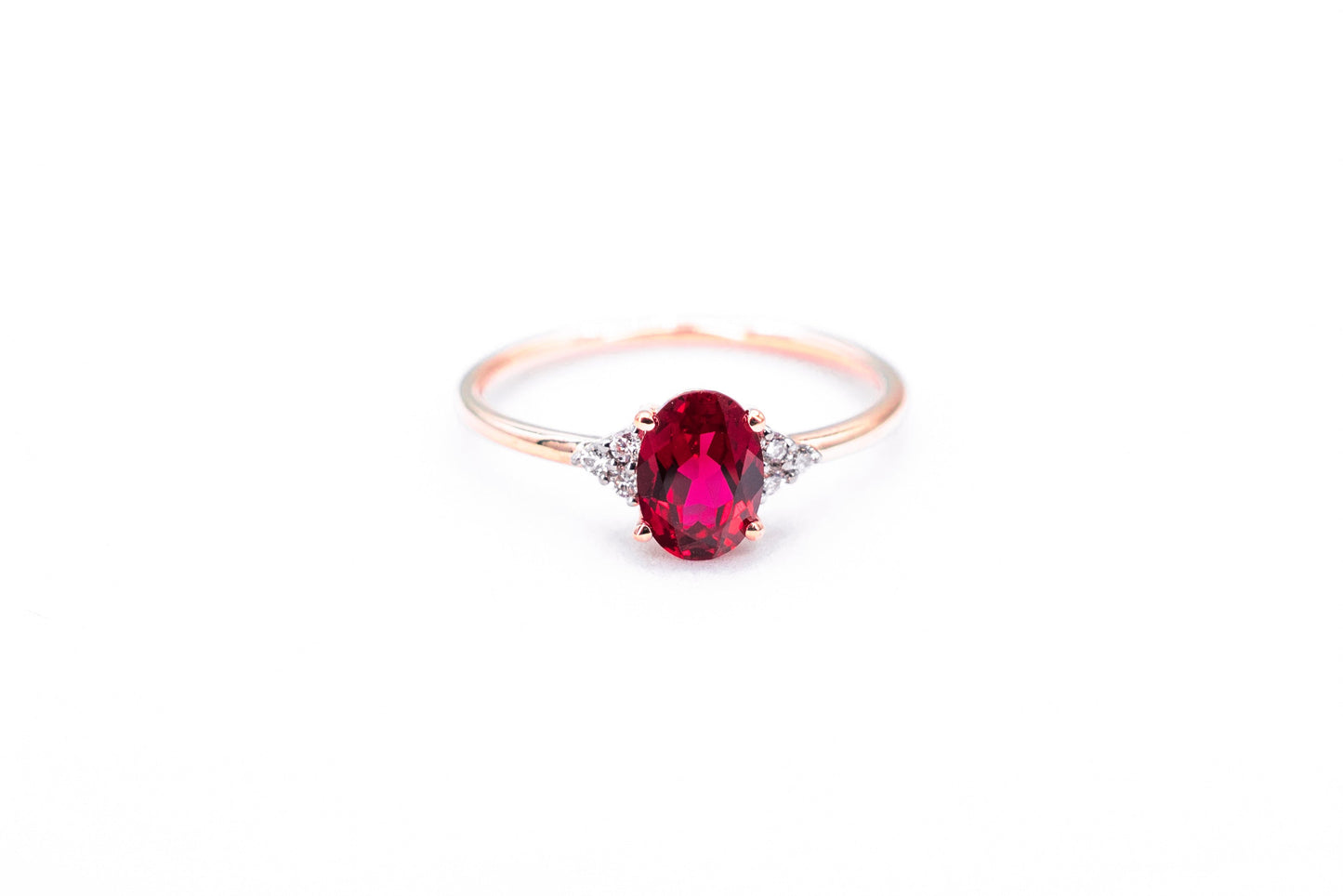 Oval ruby rose gold ring with diamond accents front view