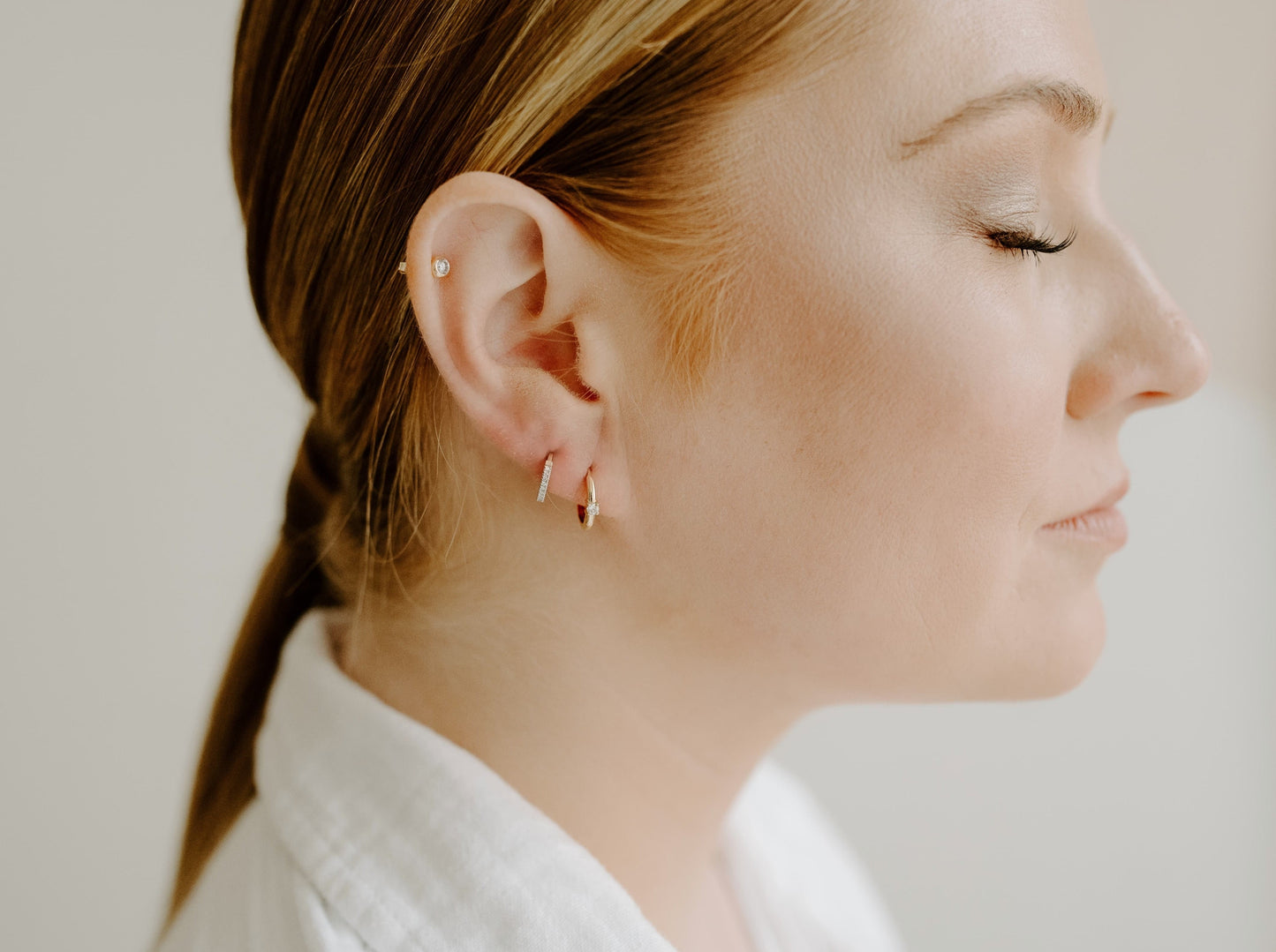 14k yellow gold, lab diamond hoop earrings being worn on ear, side view