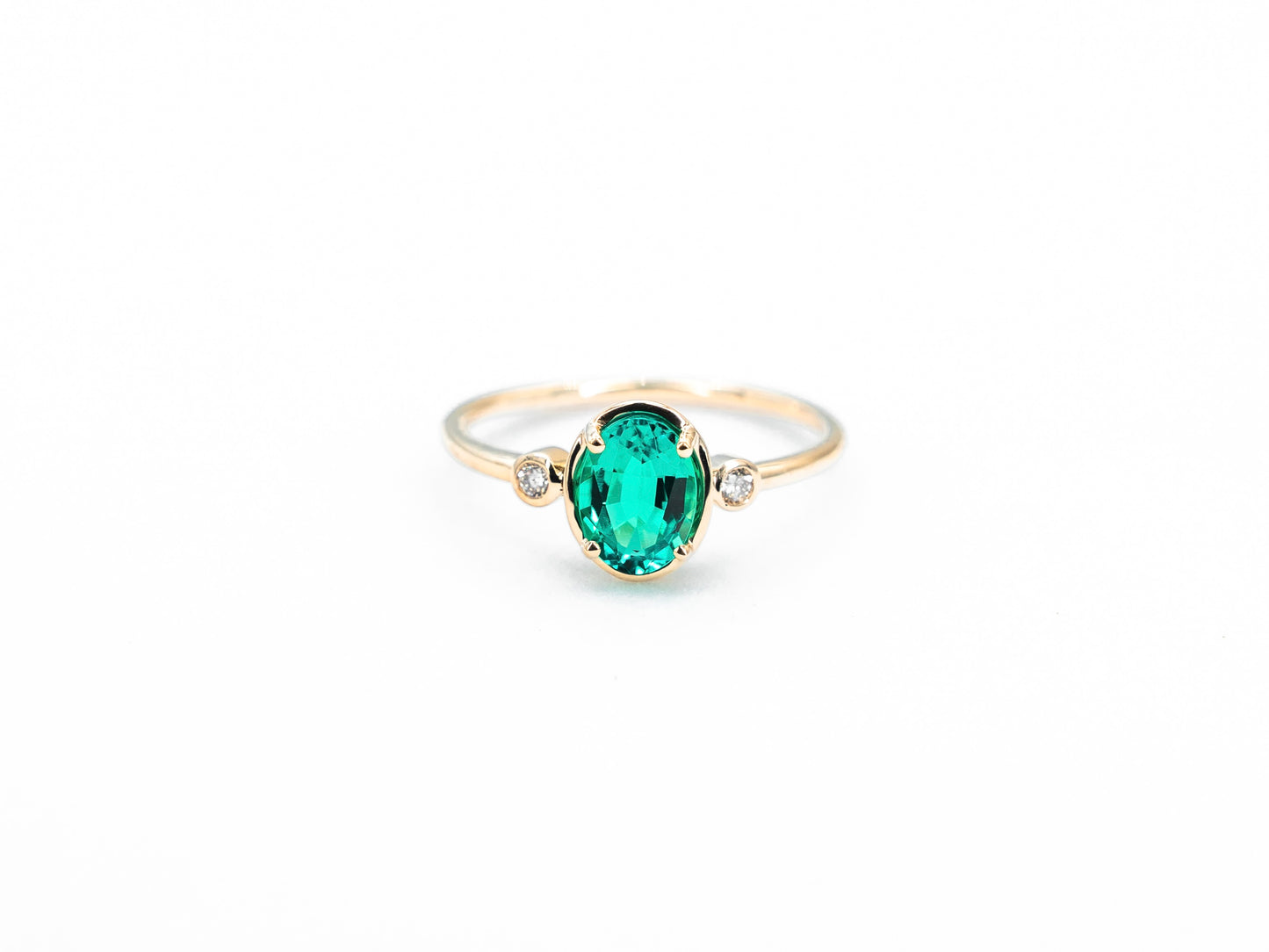Bezel set oval emerald diamond ring yellow gold front view