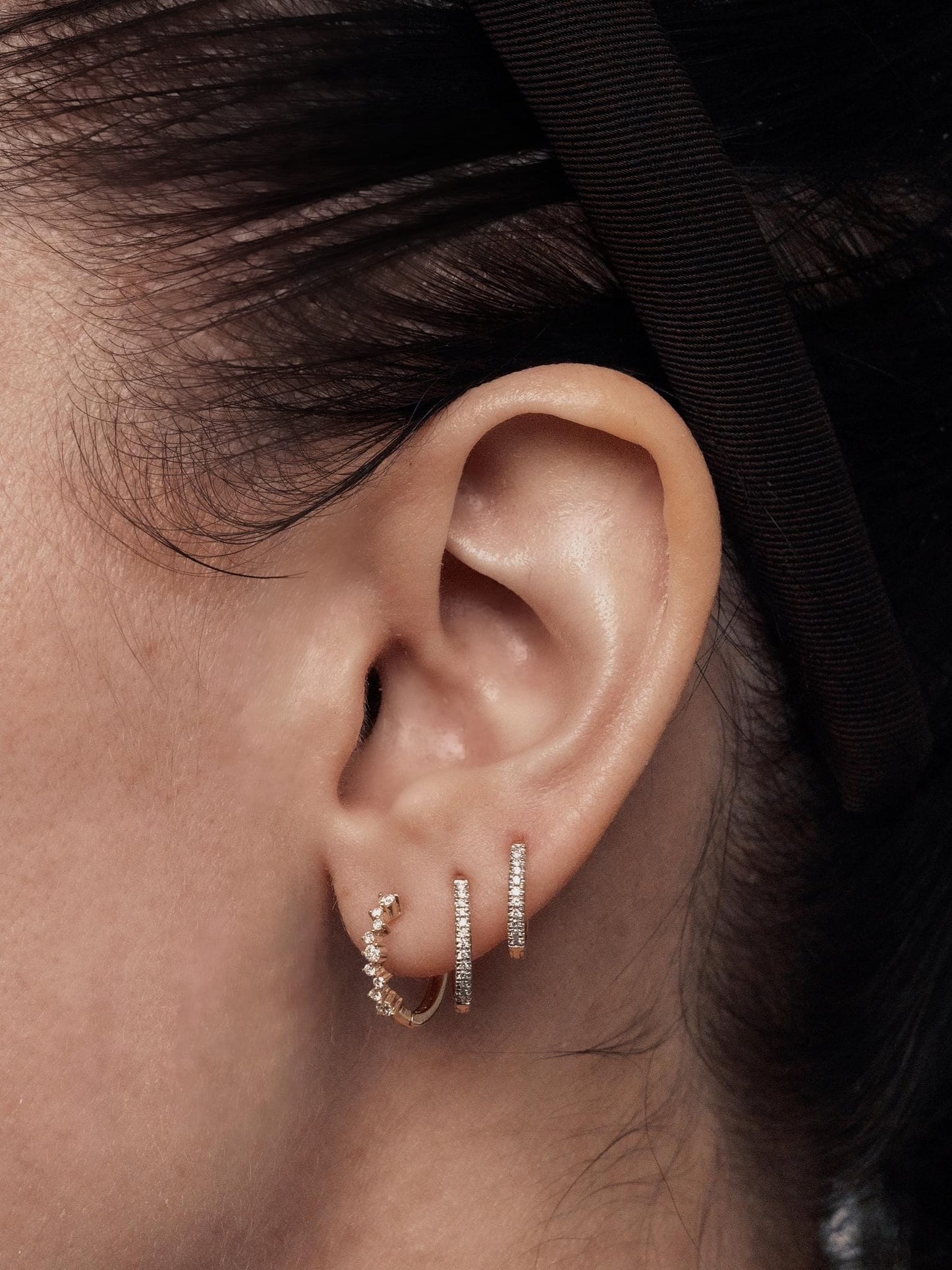 14k gold, scattered lab diamond hoop earrings being worn on ear, side view