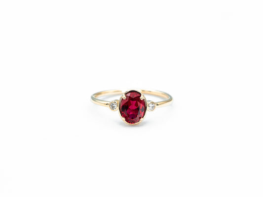 Oval ruby and diamond bezel set ring in yellow gold, front view