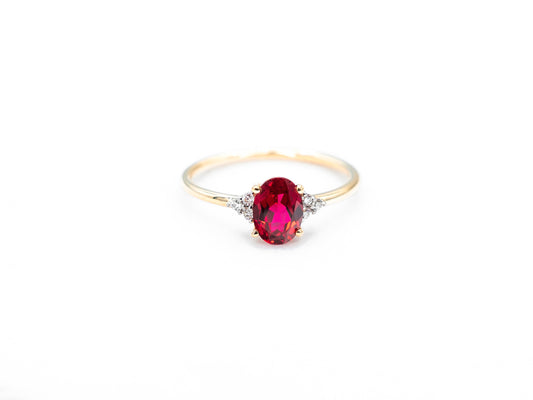 Oval ruby yellow gold ring with diamond accents front view