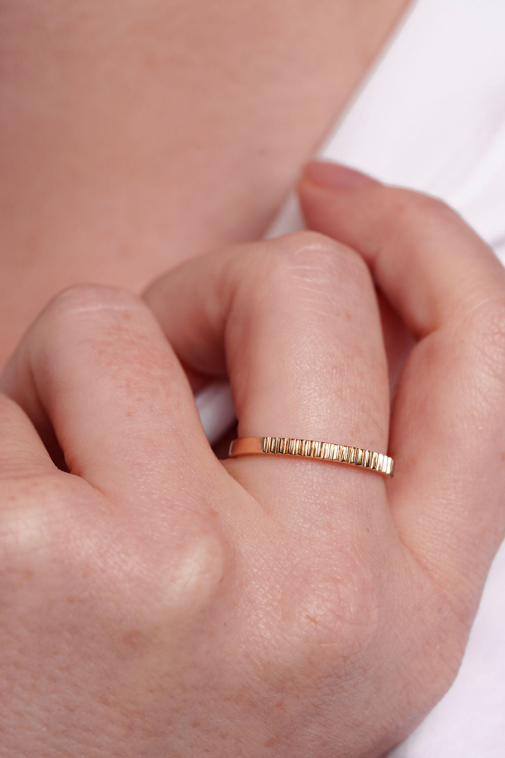 Gold ring on a person's finger with a blurred background